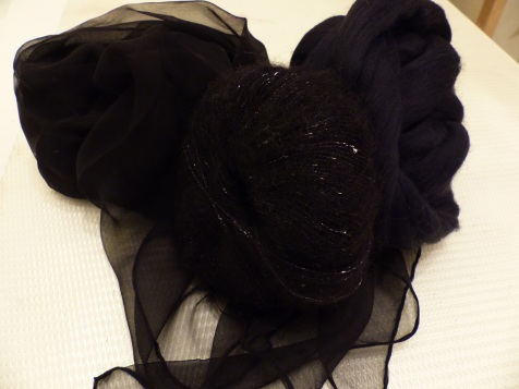 Zutaten für den Ausgehschal: schwarzer Chiffon, feine schwarze Merinowolle, schwarze Seiden-Mohairmischung mit Lurexfaden